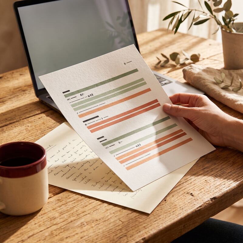 Close-up of printed search query reports being reviewed by hand, identifying pages losing clicks to AI Overviews